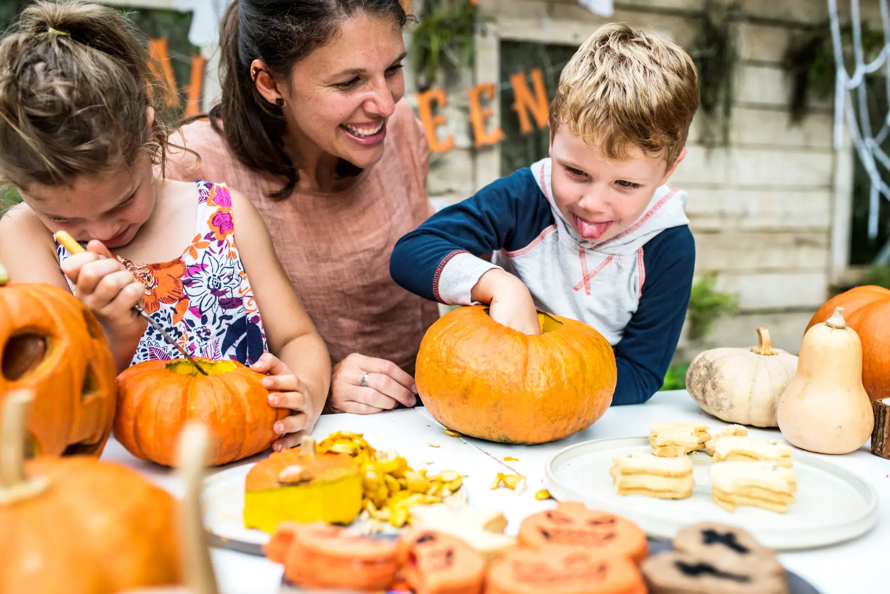 Children and parent carving pumpkins together.
